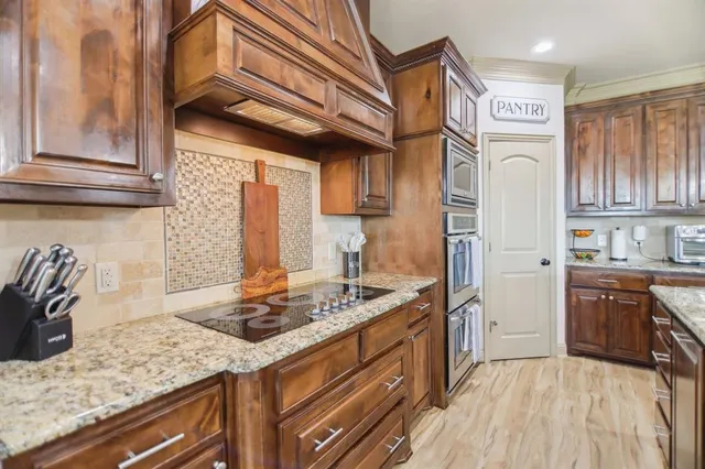 a kitchen with stainless steel appliances granite countertop a sink stove and cabinets