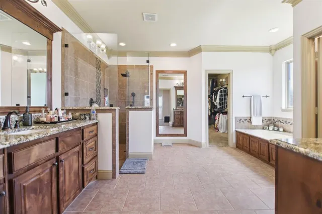 a large bathroom with a large mirror vanity and shower