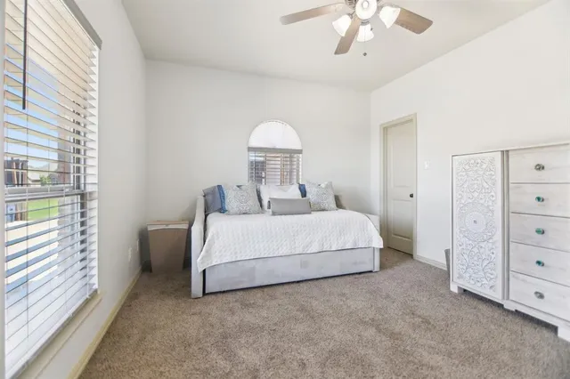 a bedroom with a bed and a chandelier fan