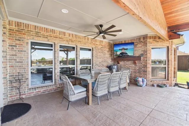 a view of a patio with a table and chairs and a barbeque