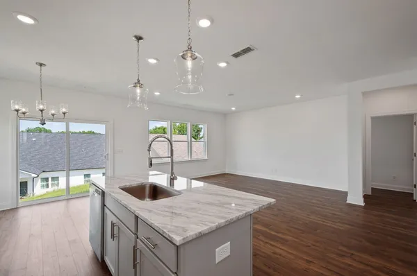 a kitchen with kitchen island a sink stainless steel appliances and wooden floor