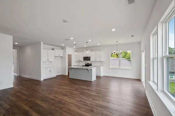 a large kitchen with stainless steel appliances kitchen island a large counter top and a wooden floors