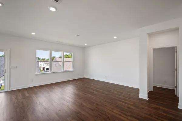 an empty room with wooden floor and window