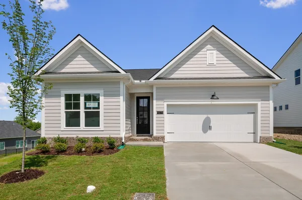 a front view of a house with a yard and garage
