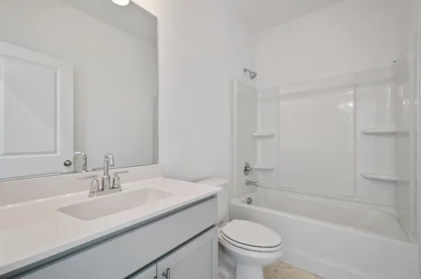 a bathroom with a granite countertop sink a toilet and shower