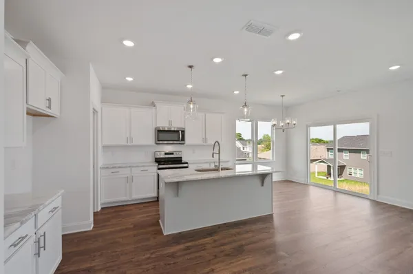 a kitchen with stainless steel appliances kitchen island wooden cabinets and granite counter tops