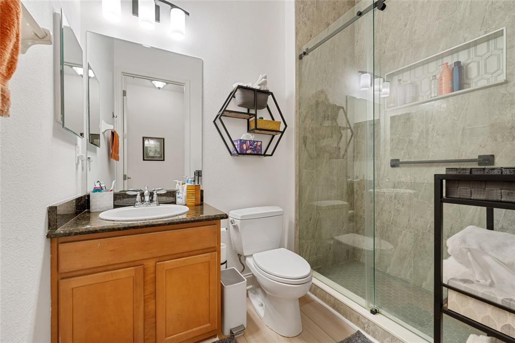 1819 Common Way Road, Unit 203 Orlando, FL 32814 - Photo 23 of 23 a bathroom with a toilet sink vanity shower and mirror