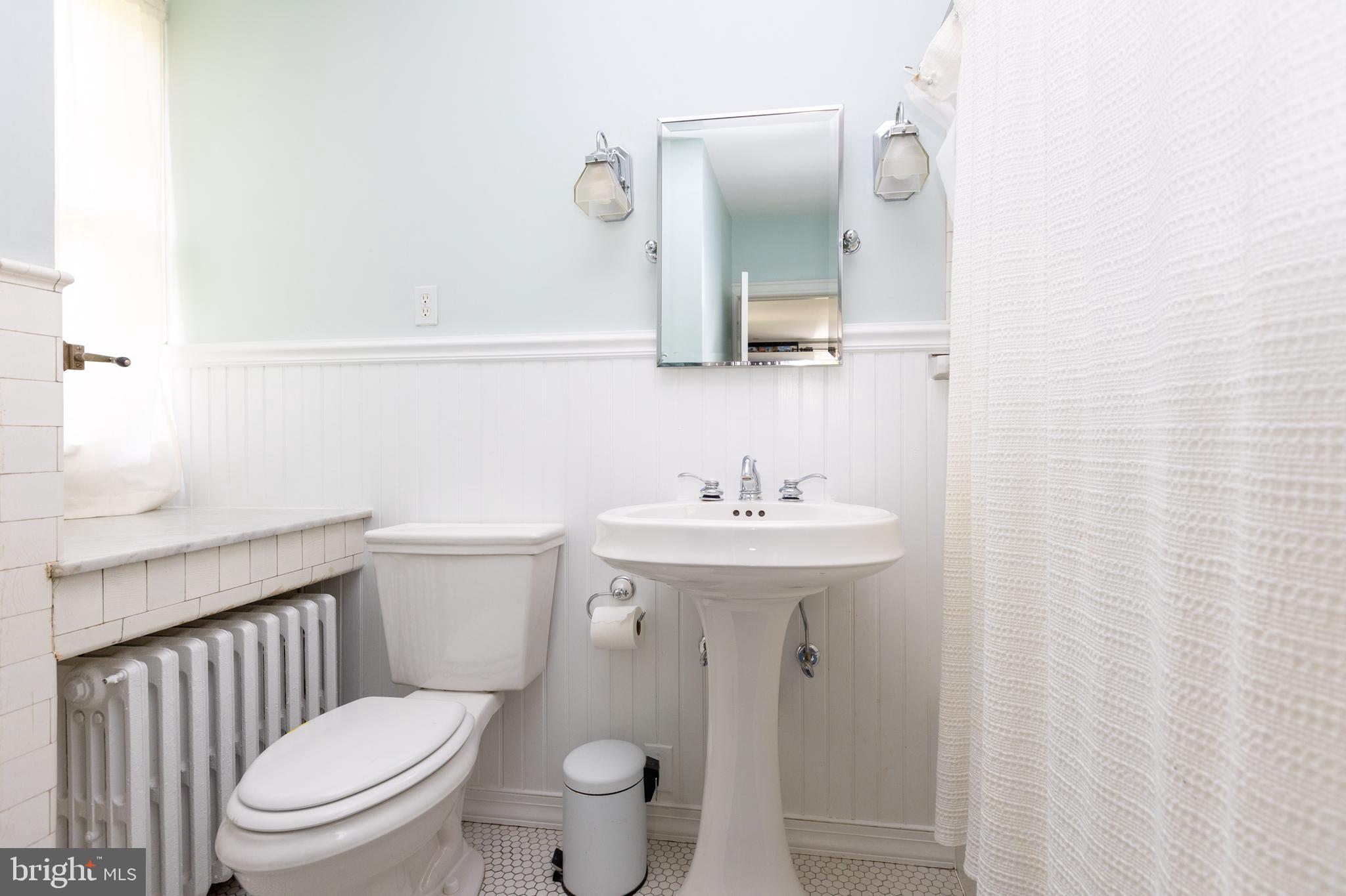4711 Roland Avenue Baltimore, MD 21210 - Photo 45 of 68 a bathroom with a toilet a sink and mirror