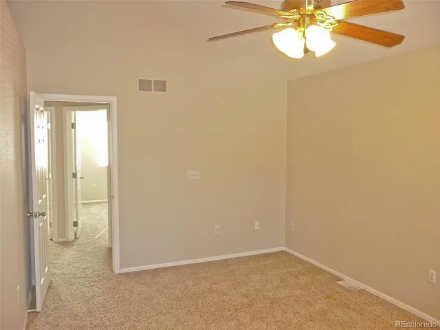 an empty room and a chandelier fan