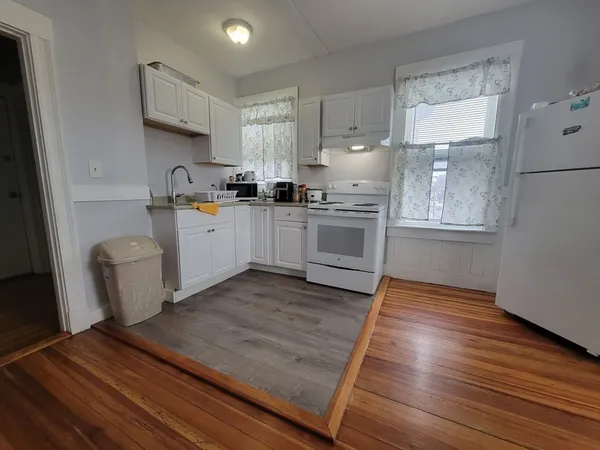 a kitchen with wooden floors and white appliances