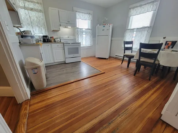 a kitchen with cabinets and wooden floor