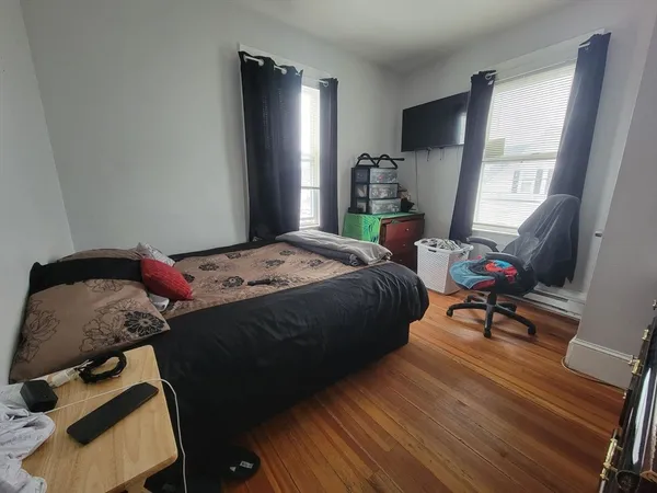 a bedroom with a bed and wooden floor