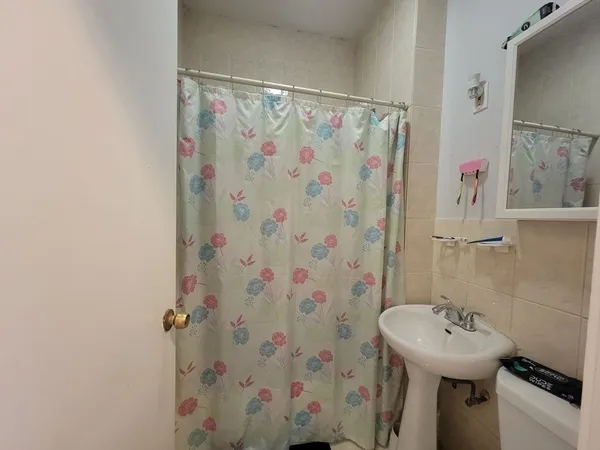 a bathroom with a sink a toilet and shower curtain