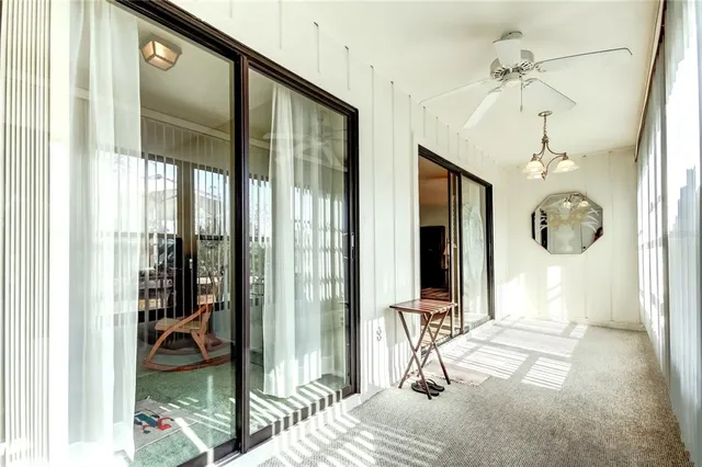 a view of a hallway with a chandelier and living room
