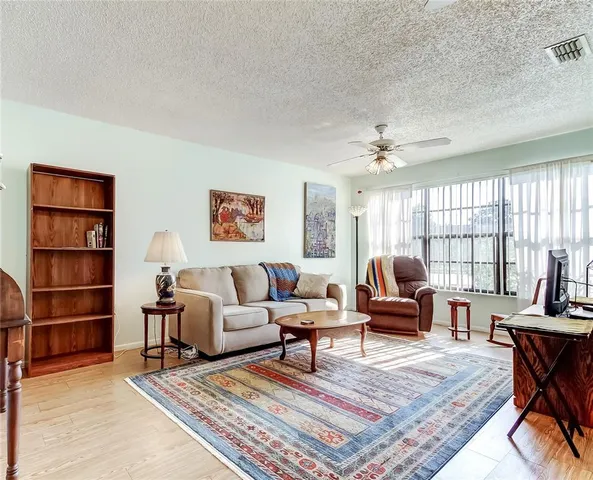 a living room with furniture a rug and a large window