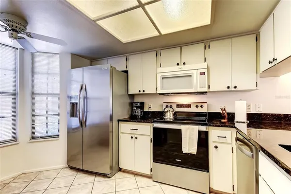 a kitchen with stainless steel appliances granite countertop a refrigerator sink and cabinets