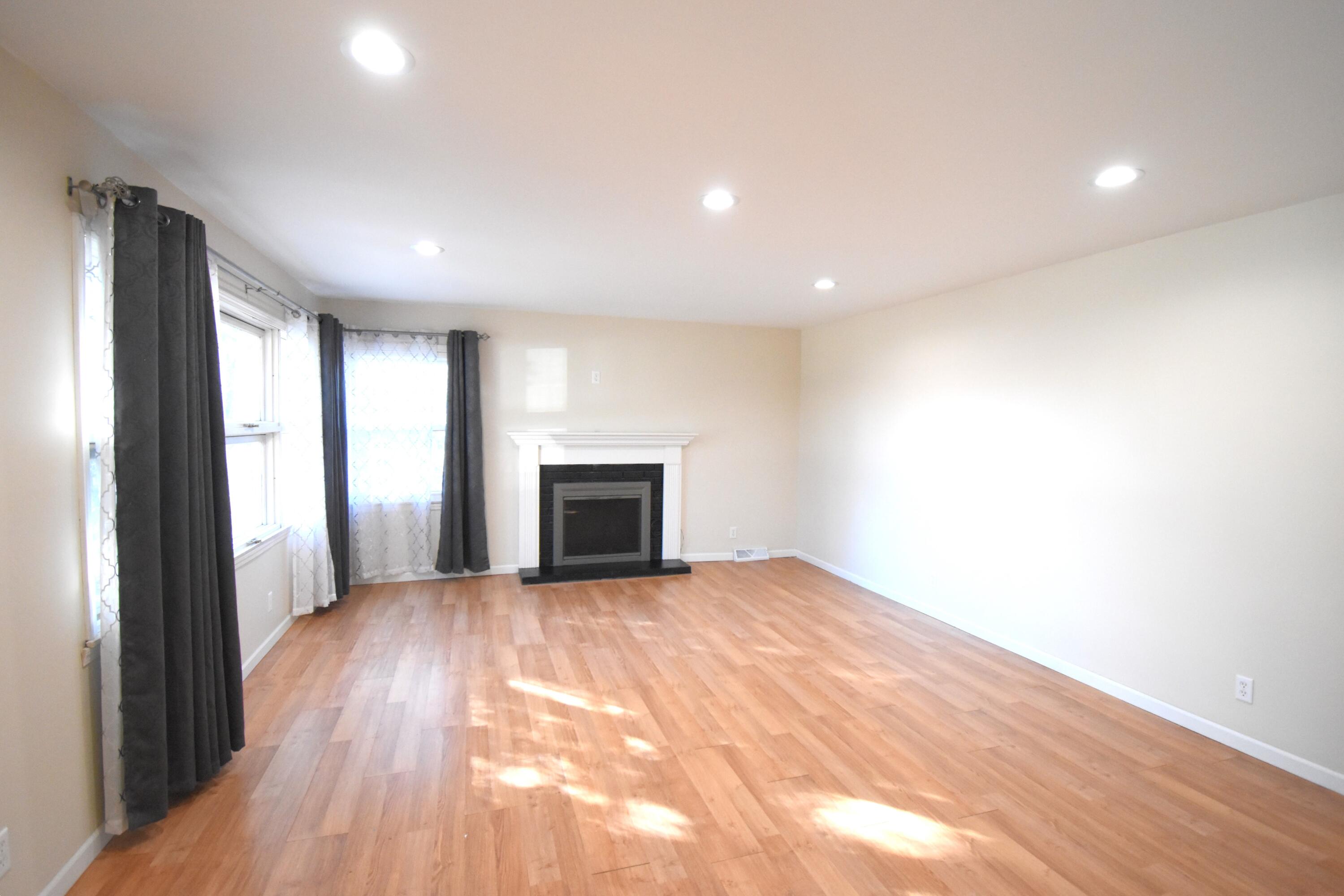 360 East Arnotts Drive Rensselaer, IN 47978 - Photo 11 of 39 an empty room with windows fireplace and wooden floor
