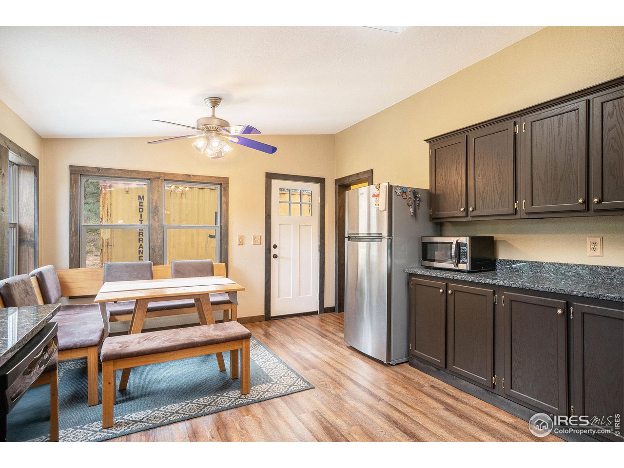 50 Pine Drive Lyons, CO 80540 - Photo 6 of 39 a living room with stainless steel appliances granite countertop a refrigerator a stove a sink dishwasher with a dining table and chairs with wooden floor