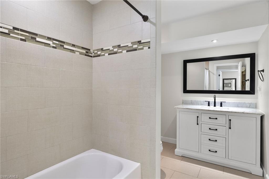 210 29th Street Southwest Naples, FL 34117 - Photo 11 of 17 a bathroom with a granite countertop sink a mirror and a bathtub