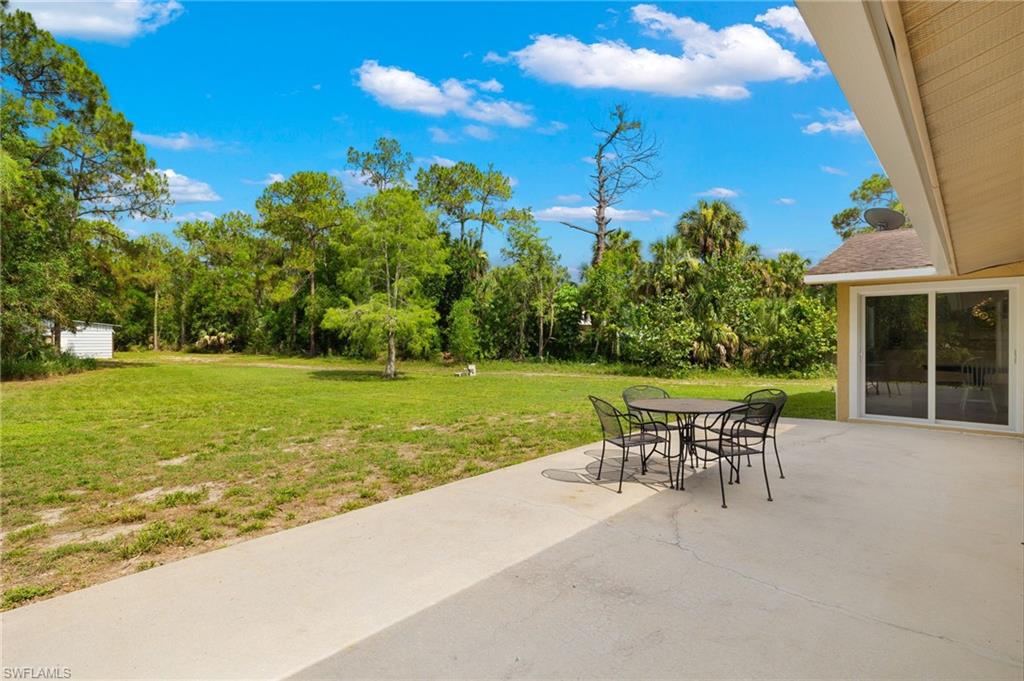 210 29th Street Southwest Naples, FL 34117 - Photo 12 of 17 a patio with table and chairs and potted plants