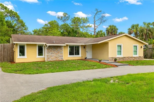 a patio with table and chairs and potted plants