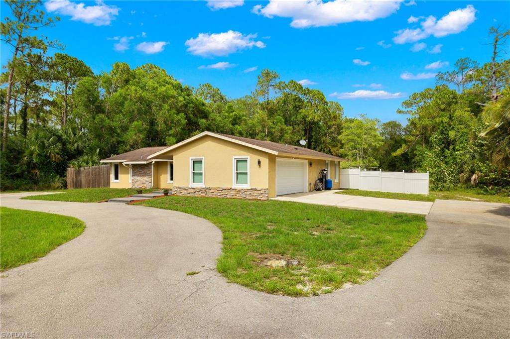 210 29th Street Southwest Naples, FL 34117 - Photo 14 of 17 a front view of a house with garden