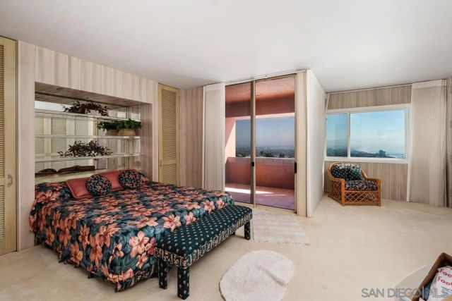 a bedroom with a bed and large mirror