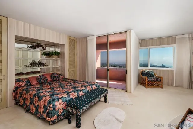 a bedroom with a bed and large mirror