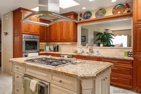 a large kitchen with stainless steel appliances granite countertop a large stove and a sink