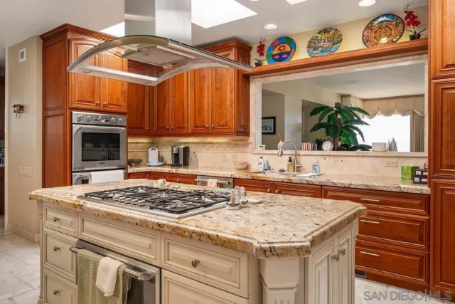 a large kitchen with stainless steel appliances granite countertop a large stove and a sink