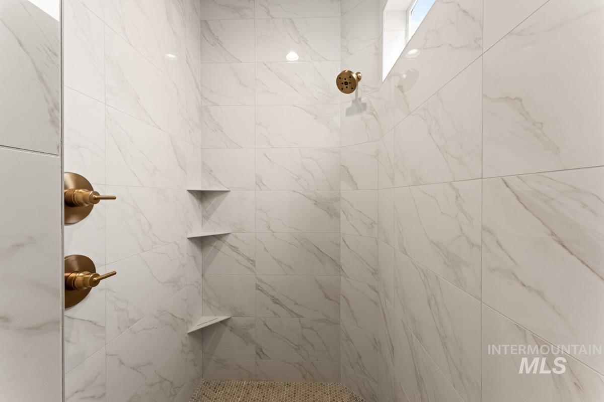 13338 North Spring Creek Way Boise, ID 83714 - Photo 21 of 46 Shower featuring white marble-look wall tiles and a small upper window