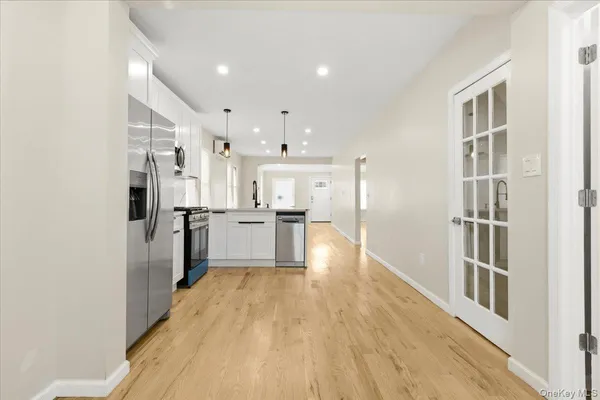a open kitchen with white cabinets and stainless steel appliances