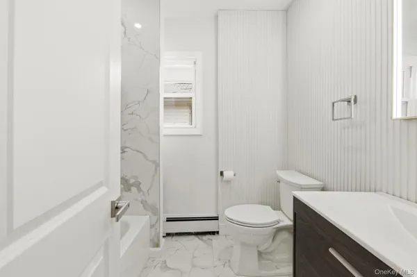 a bathroom with a sink a toilet a mirror and shower