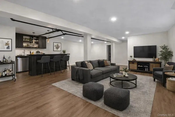 a living room with furniture a flat screen tv and kitchen view