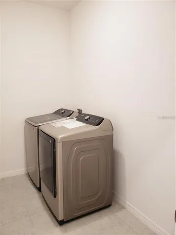 a front view of a building with garden and trees