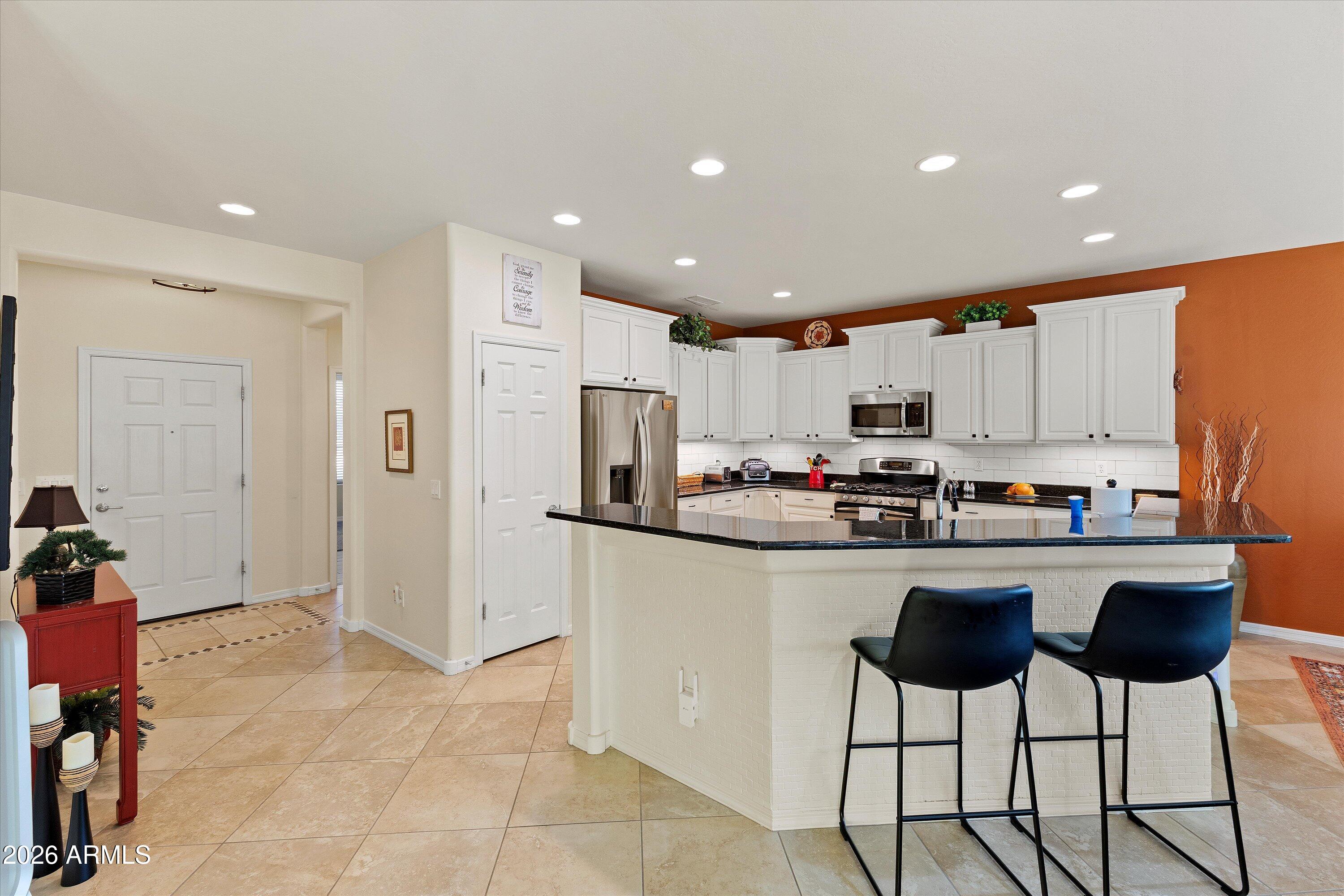 20652 North 267th Avenue Buckeye, AZ 85396 - Photo 10 of 53 a kitchen with stainless steel appliances granite countertop a refrigerator and a stove top oven
