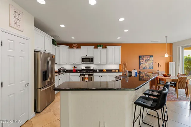 a living room with furniture kitchen view and a window
