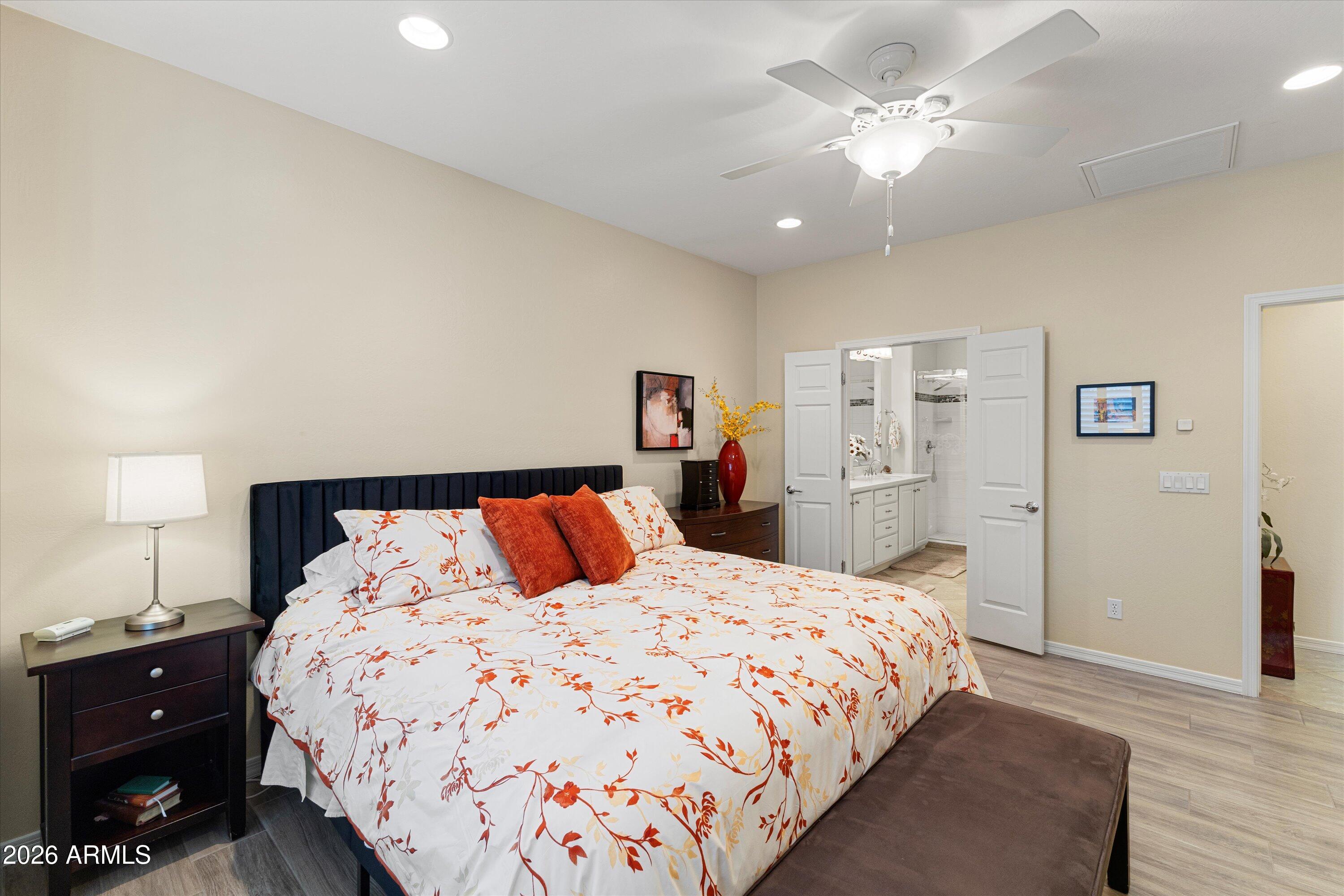 20652 North 267th Avenue Buckeye, AZ 85396 - Photo 25 of 53 a bedroom with a large bed and a chandelier