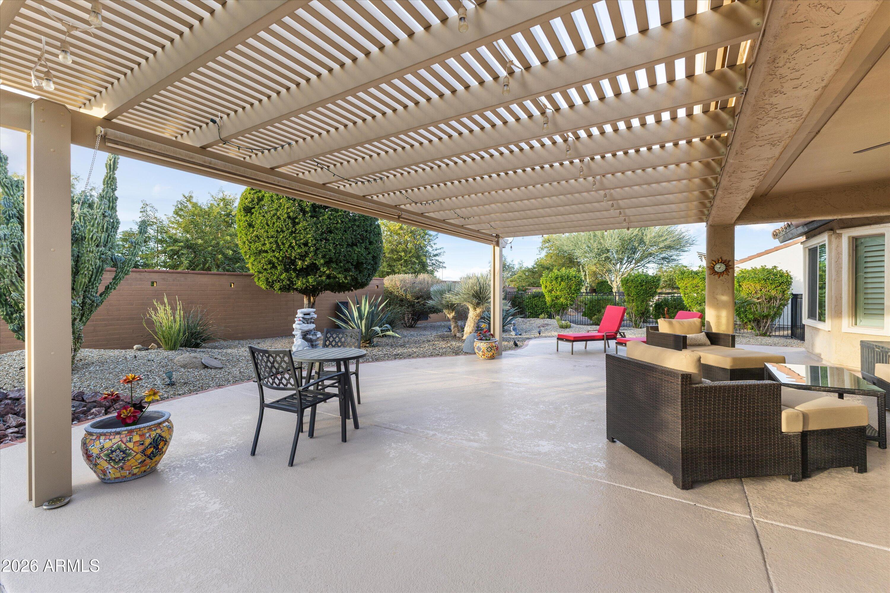 20652 North 267th Avenue Buckeye, AZ 85396 - Photo 37 of 53 a view of a patio with table and chairs potted plants and floor to ceiling window