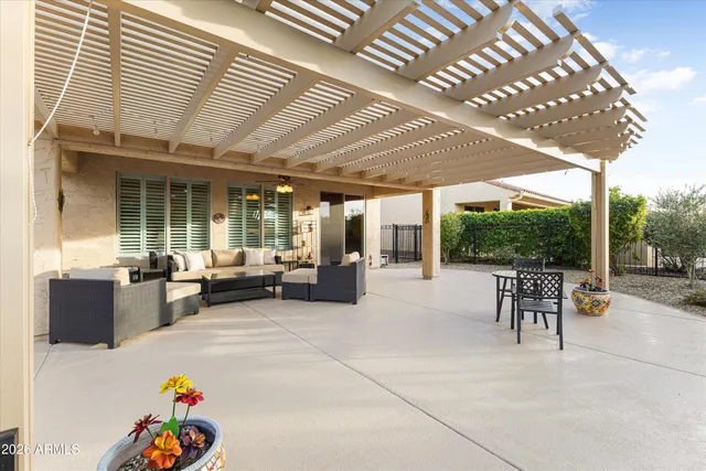 a view of a patio with table and chairs potted plants and floor to ceiling window