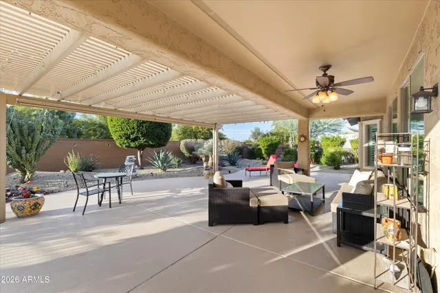 a view of a patio with couches table and chairs and potted plants