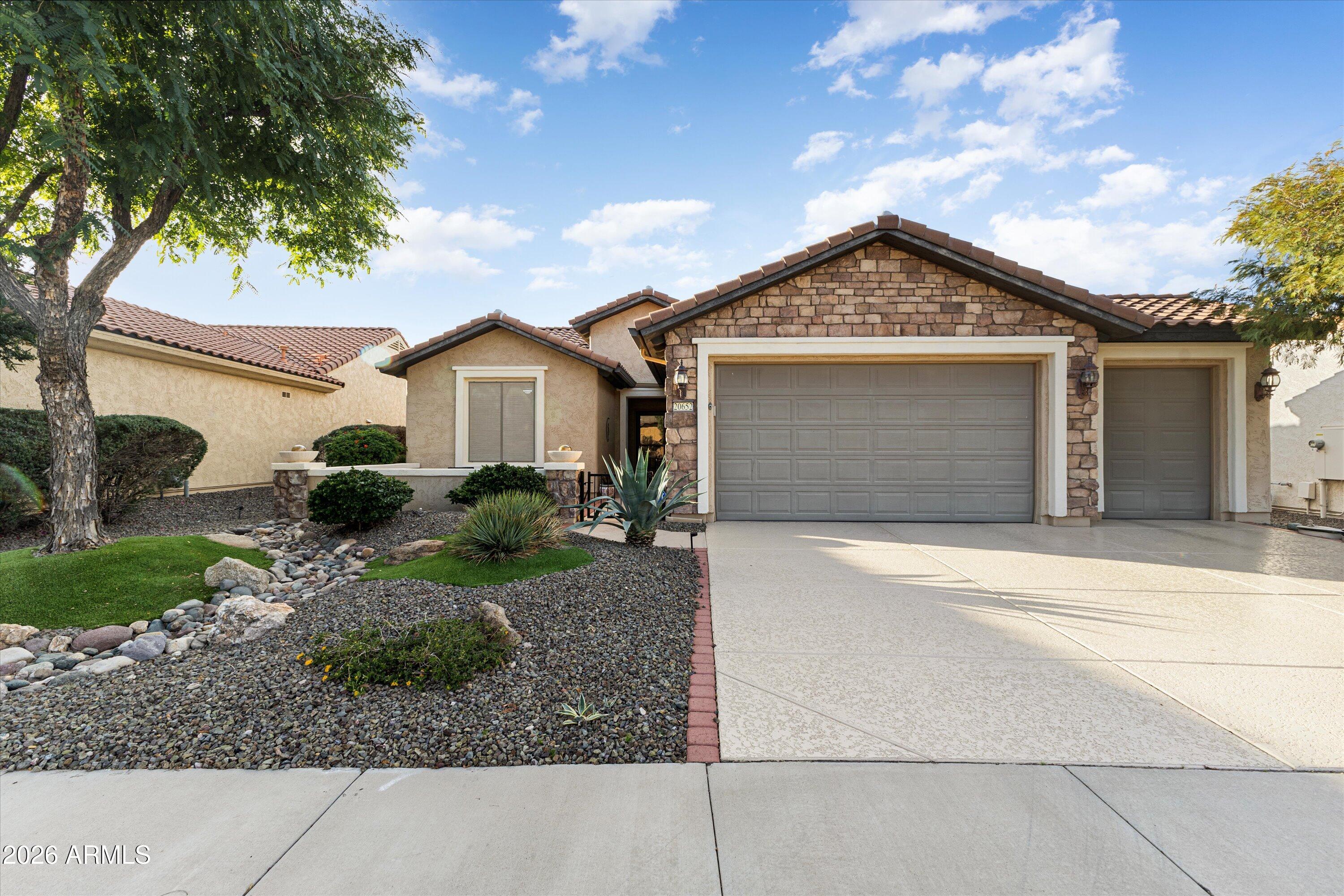 20652 North 267th Avenue Buckeye, AZ 85396 - Photo 4 of 53 a front view of a house with a yard and garage