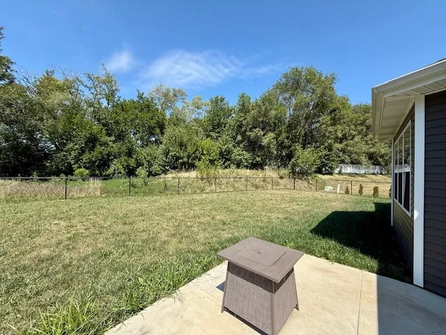 a view of a yard with wooden fence