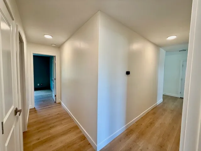 a view of a hallway with wooden floor
