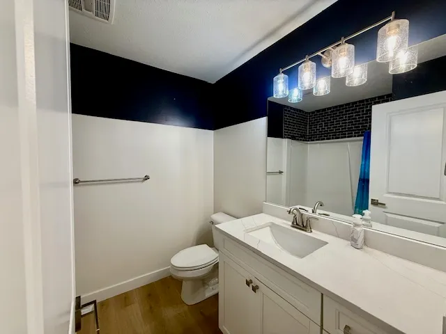 a bathroom with a sink a toilet and a mirror