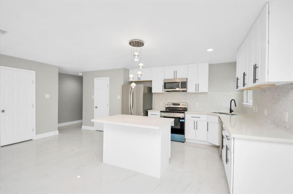 a kitchen with stainless steel appliances granite countertop a refrigerator sink stove and oven