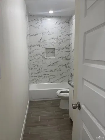 a bathroom with a toilet and a shower