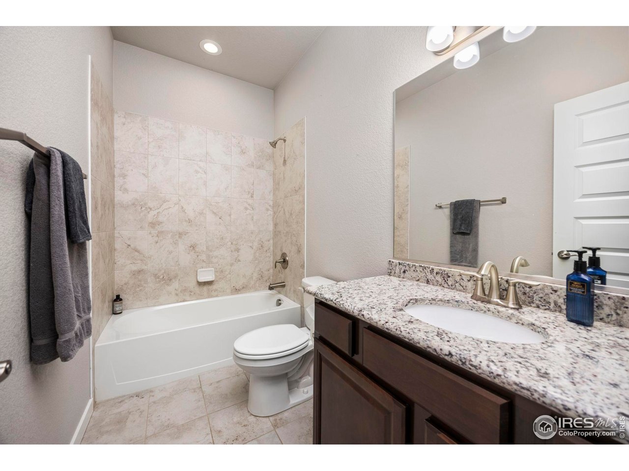 1344 87th Avenue Greeley, CO 80634 - Photo 16 of 31 a bathroom with a granite countertop sink toilet and shower