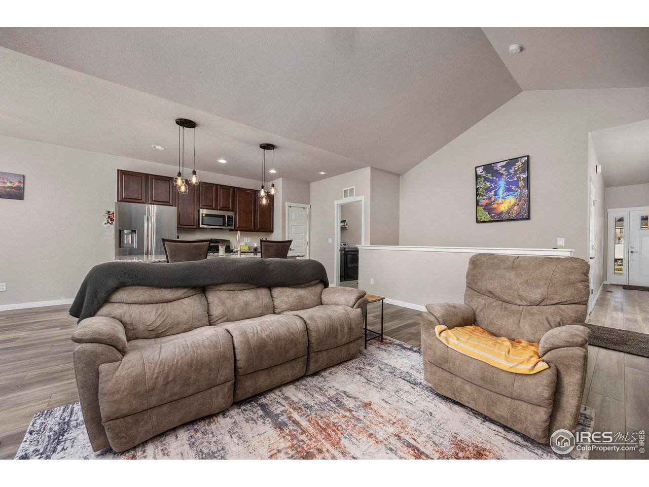 1344 87th Avenue Greeley, CO 80634 - Photo 6 of 31 a living room with furniture and a chandelier
