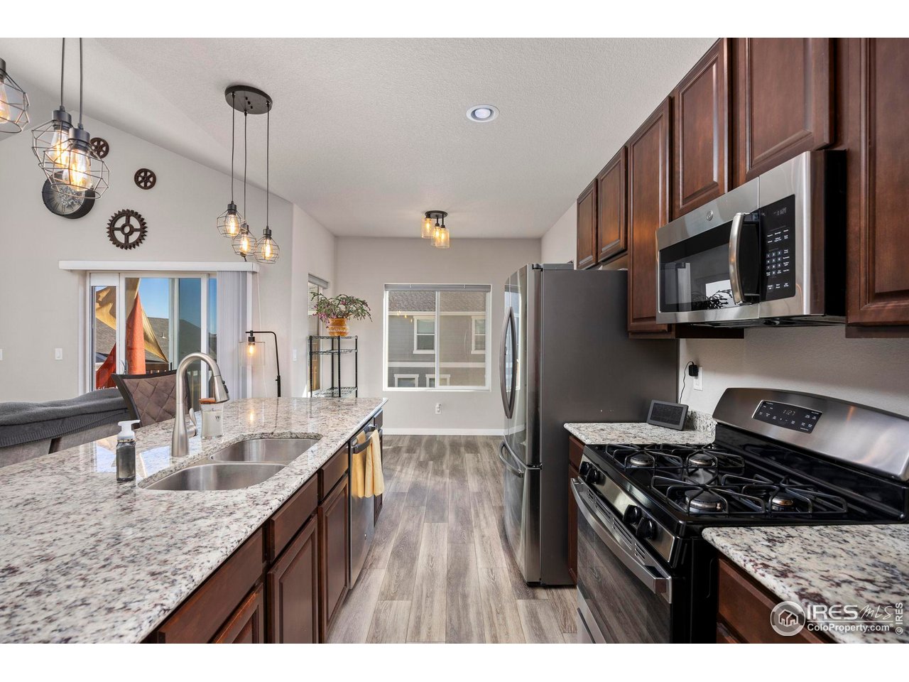 1344 87th Avenue Greeley, CO 80634 - Photo 8 of 31 a kitchen with stainless steel appliances granite countertop a lot of cabinets a stove and a refrigerator